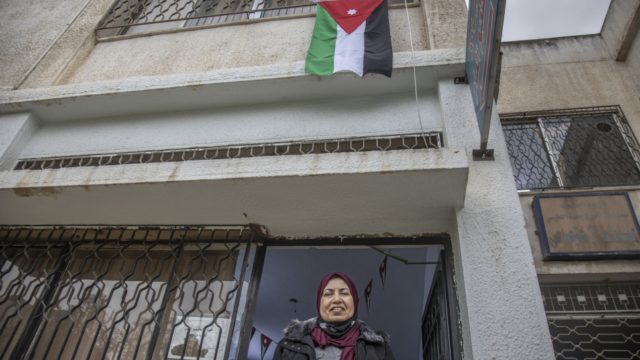Raia Al Kabashi se tient sous le drapeau jordanien devant le centre de santé d’Irbid où elle a reçu son vaccin contre la Covid-19