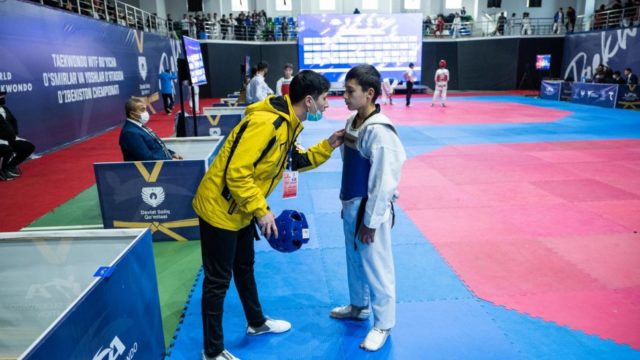 Mukhamadjon donne des instructions à son élève lors d’un tournoi de taekwondo.