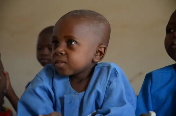 Azaiya sits in the front row of his class in Ikyogen settlement, Nigeria.