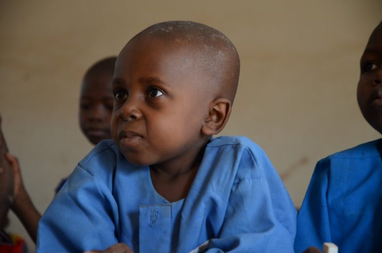 Azaiya sits in the front row of his class in Ikyogen settlement, Nigeria.