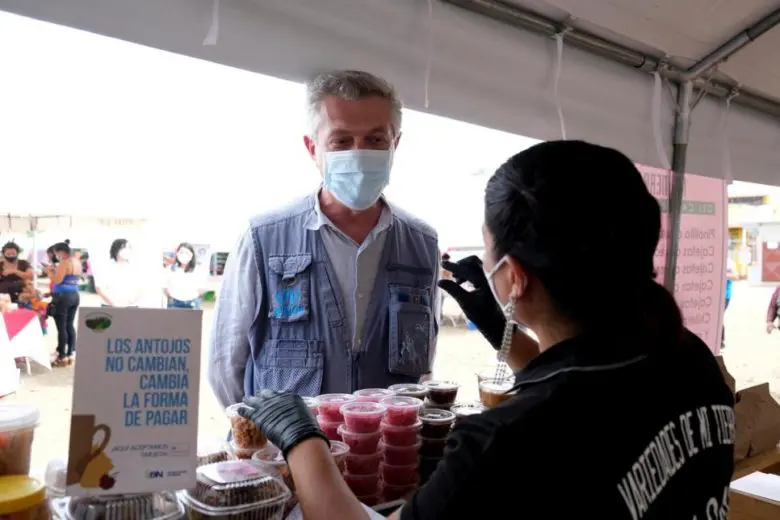 Le Haut Commissaire des Nations Unies pour les réfugiés, Filippo Grandi, s’entretient avec Carmen*, une demandeuse d’asile nicaraguayenne, près de son stand dans un marché d’Upala, au Costa Rica. 