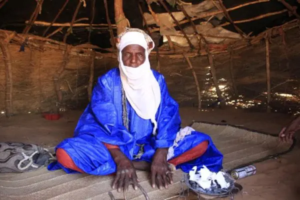 Man seated inside a shelter.