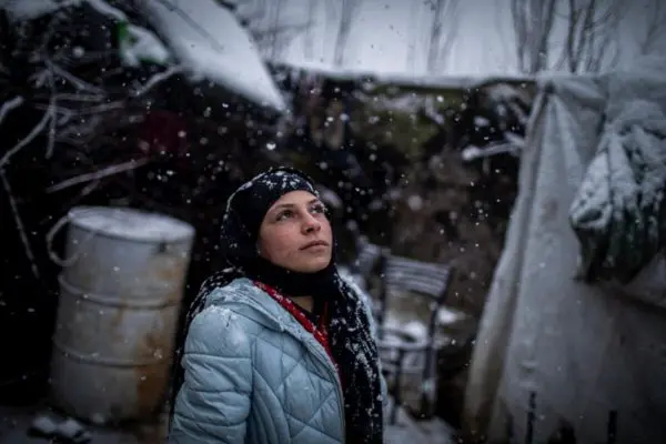 A young Syrian refugee outside her home in an informal settlement camp in Beqaa Valley, Lebanon