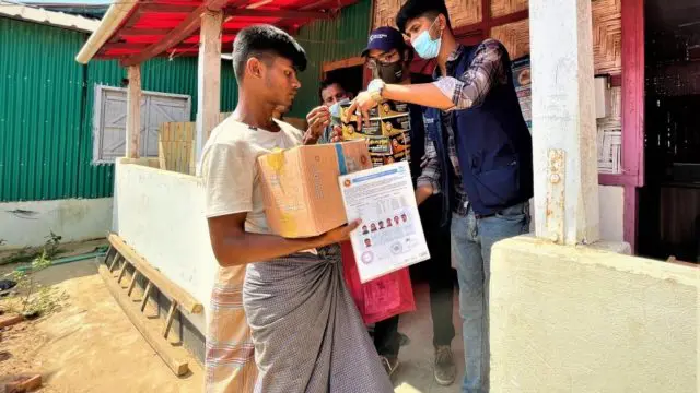 Refugee volunteers deliver aid to families affected by the fire.