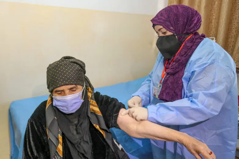 Woman receives a vaccine by a nurse.