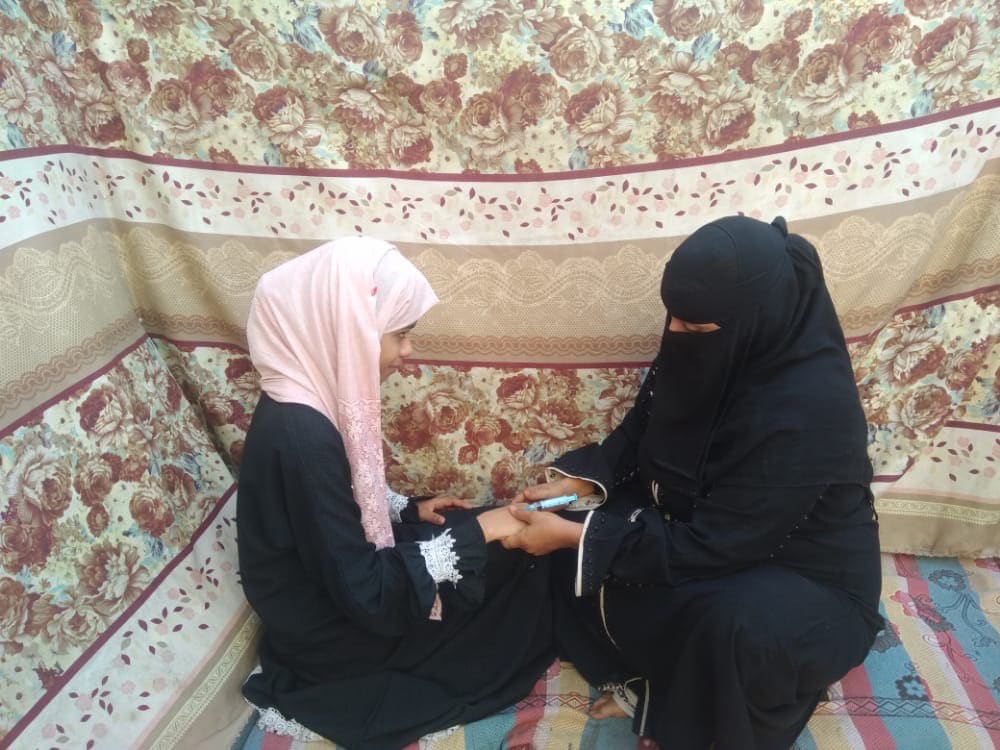 Nabiha, une femme déplacée au Yémen, s'occupe d'un patient.