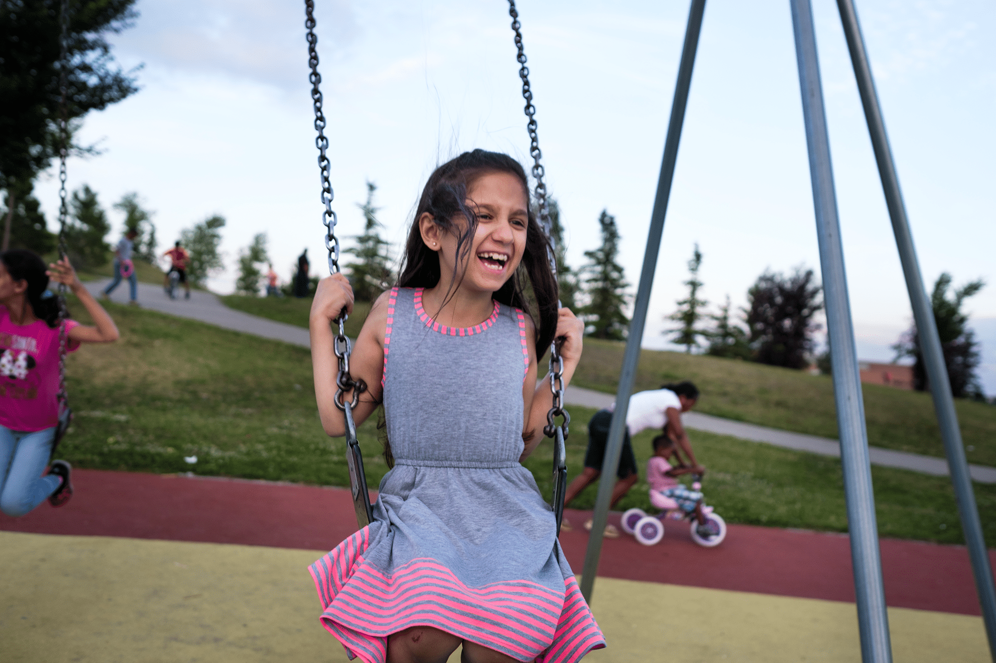 Syrian refugee Maryam is seen on a swing in the park.