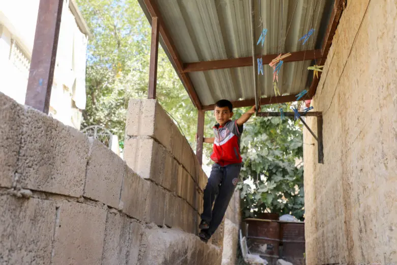 Syrian refugee Odai plays outside his home in Amman, Jordan. 