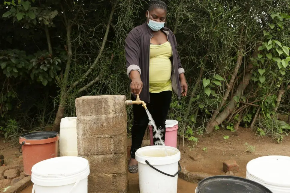 Josephine Mbayo uses one of the newly installed taps in Tongogara refugee camp to fill a bucket of water.