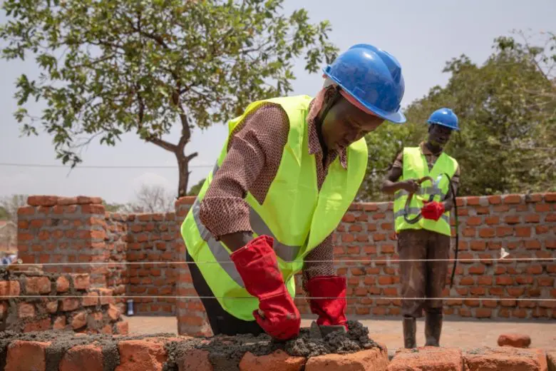 Construction worker building a wall out of bricks.