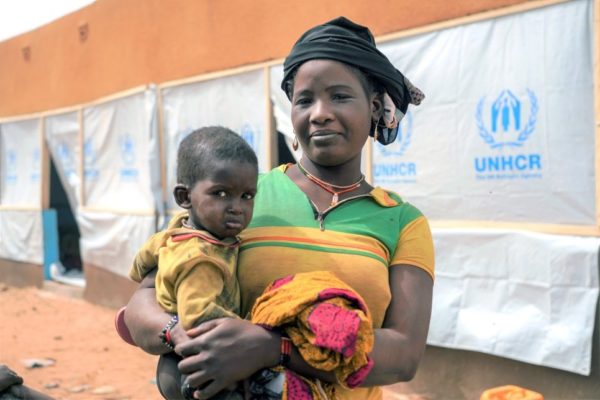 Aïssata, de retour au camp de Goudoubo depuis Djibo, tient son bébé dans les bras.