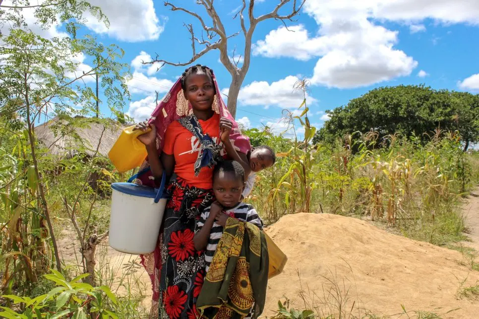 Une déplacée interne, photographiée avec ses enfants, va collecter de l’eau sur le site de déplacés d’Intele dans le district de Montepuez, Cabo Delgado, Mozambique. 