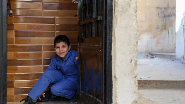Jameela’s youngest son Ahmed, 8, in the doorway of their apartment.