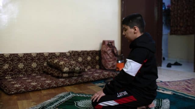 Ali, 12, prays at home.