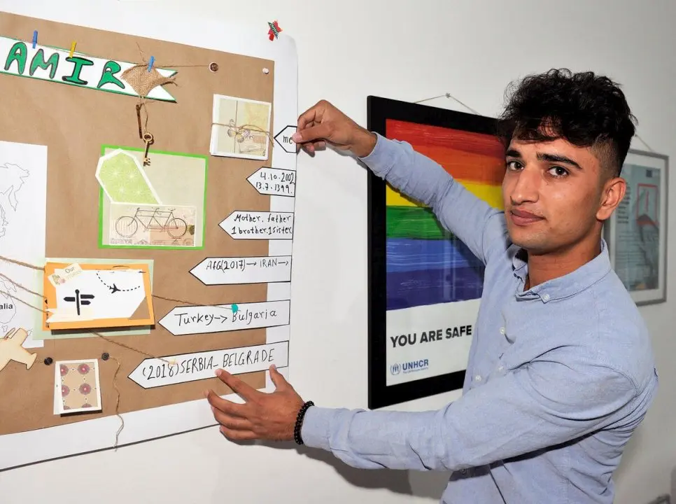 Arsalan points to a poster at a workshop on the risks of exploitation and trafficking in Belgrade.