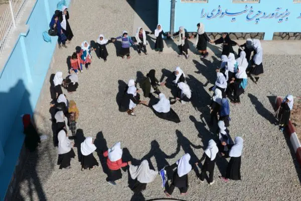 Des écolières afghanes déplacées jouent dans la cour de récréation à l’école secondaire de Kahdistan dans le district d’Injil, province d’Herat, Afghanistan.