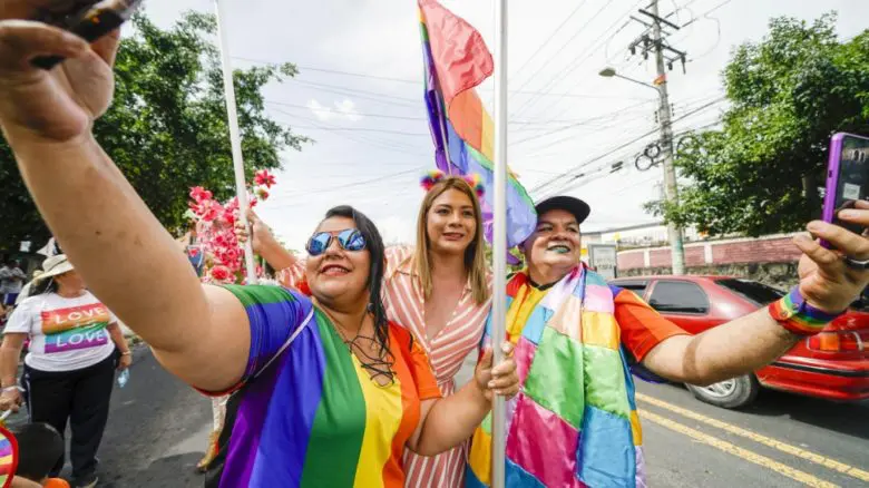 LGBTIQ1 activist Bianka Rodriguez marches with the rainbow flag at a trans rights parade.