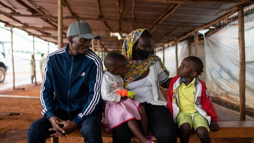 Burundian returnee Donatien, 35, sits with his family at the Kinazi Transit Center.