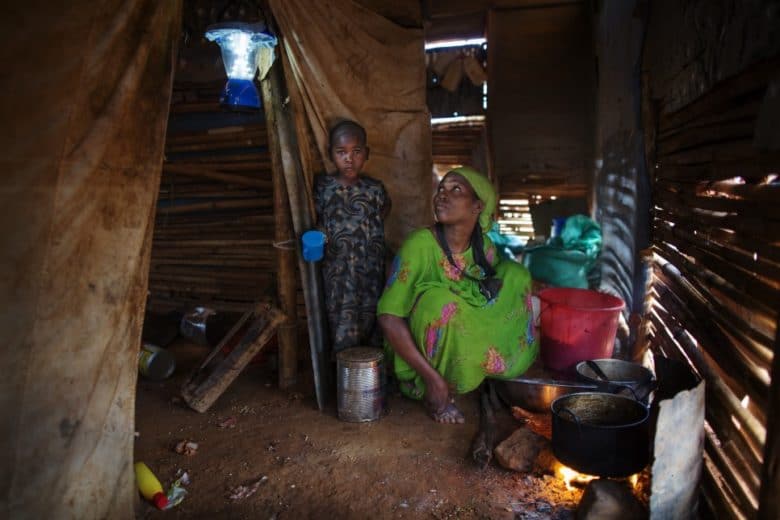 Markabo et sa fille, Maryama* cuisinent un repas sous l’éclairage d’une lanterne solaire