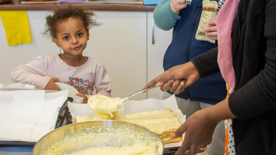 Feruz, 5 ans, regarde sa mère Mariam, 34 ans, préparer un millefeuille dans un centre de transit d’urgence à Timisoara, en Roumanie.