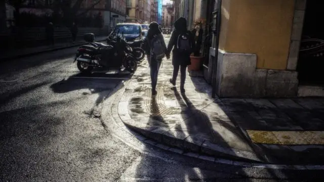 Un couple LGBTI marche main dans la main dans les rues de sa nouvelle ville, à Genève en Suisse.