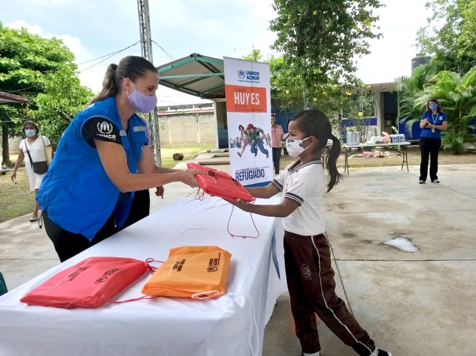 Kristin gives school kits to an elementary school student in Tapachula. 