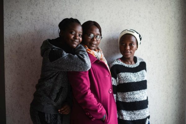 Une famille congolaise réunie : Estelle, Grace et Eliane (de gauche à droite) sont photographiées ici près de l’entrée de leur appartement à Dijon en France.