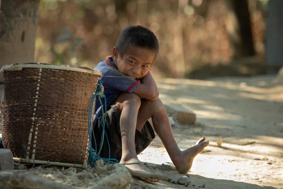 Young boy seated outside.