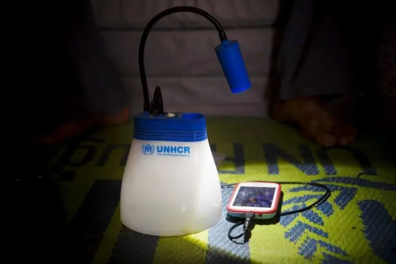 A Syrian refugee shows how the IKEA-donated lamp also doubles as a mobile phone charger in Azraq Refugee Camp, Al Azraq, Jordan