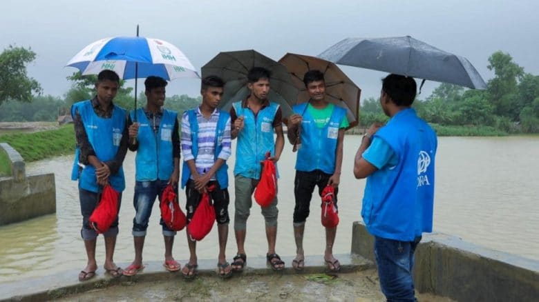 Rohingya refugee volunteers shortly after rescuing a teenager from a reservoir in Nayapara refugee camp