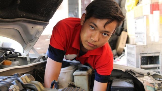 Young man working at a repair shop.