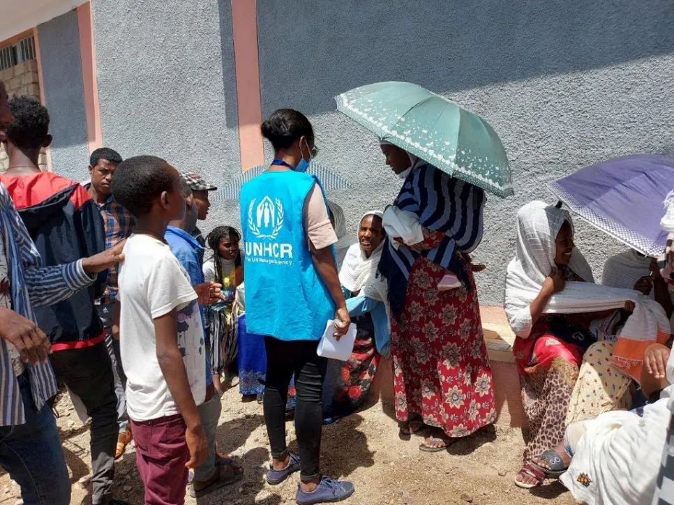 A UNHCR staff member speaks to internally displaced people.