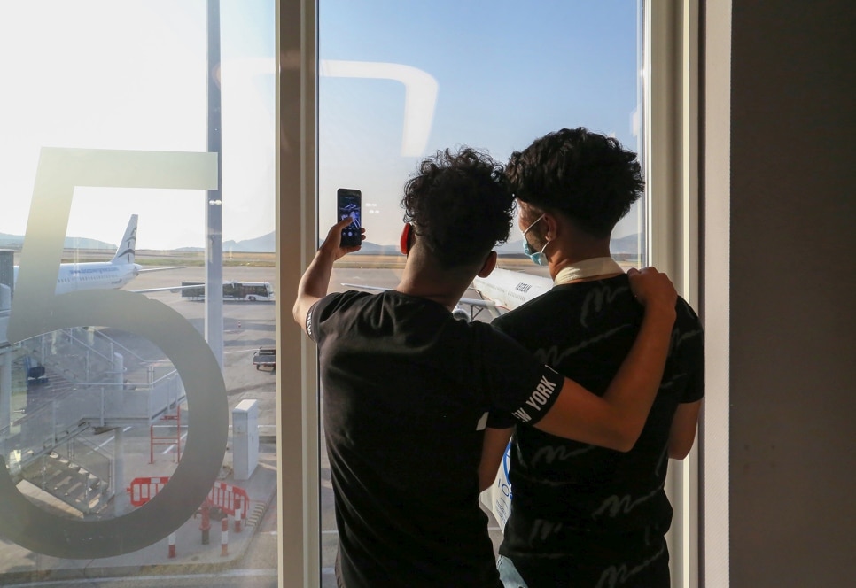 Deux enfants réfugiés font un selfie à l’aéroport.