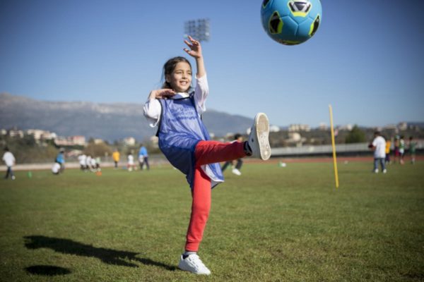Une fillette envoie un ballon au pied durant un événement de solidarité envers les réfugiés. Des associations nationales de football à travers l’Europe s’engagent à contribuer à l’insertion des réfugiés dans leurs nouvelles communautés