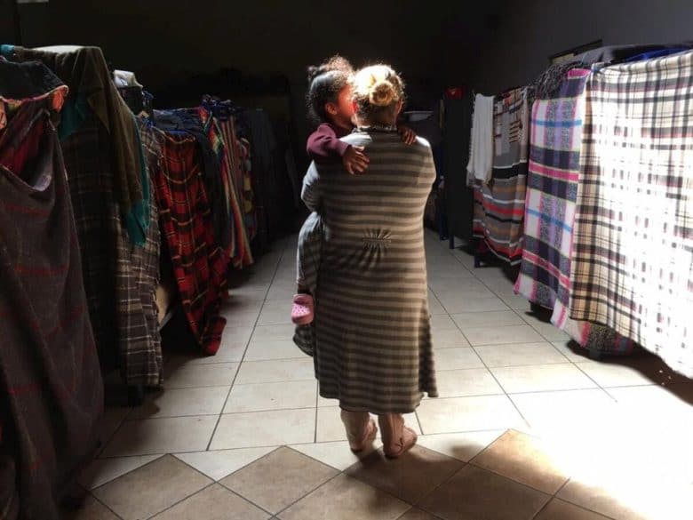 Mother holds young daughter at a shelter