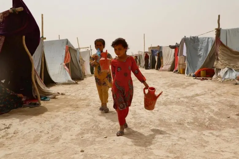 Les filles de Maryam retournent à leur abri après avoir collecté de l’eau dans le camp de Nawabad Farabi-ha.