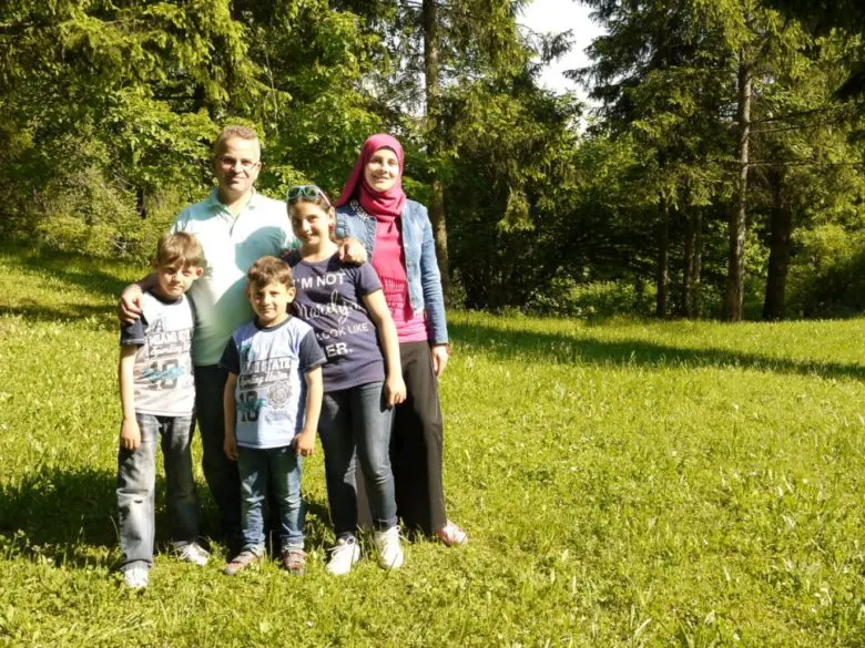 Family of five smiles while standing in nature