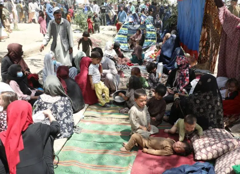 adults and children gathered around and sitting