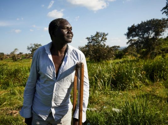 Diyo Diliga, un réfugié sud-soudanais handicapé, parcourt à pied des terres agricoles.