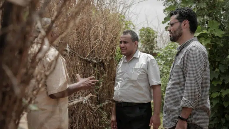 Ameen Jubran (centre), head and co-founder of Jeel Albena, talks to a displaced man at a camp near Hudaydah, Yemen