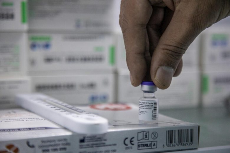 A person holding a vaccine vial