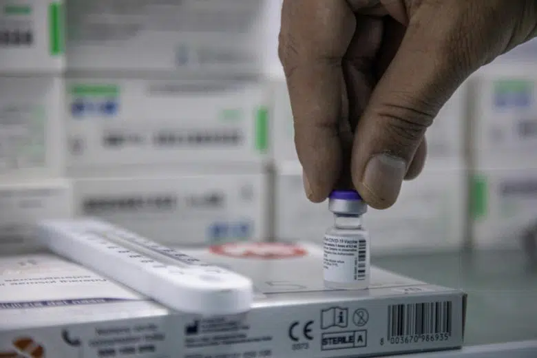 A person holding a vaccine vial