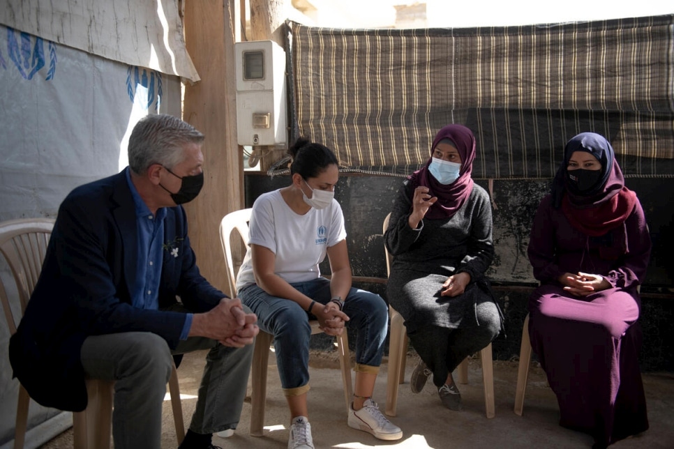 High Commissioner sitting with Syrian refugees in Lebanon