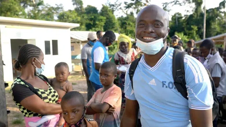 man smiling with group of kids 