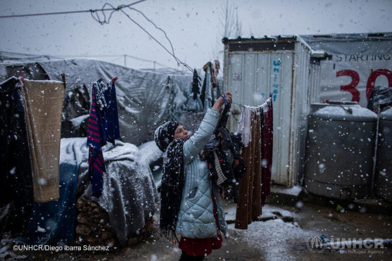 Siba Issa El Ali, a 10-year-old Syrian refugee girl from Deir ez-Zor, takes down the laundry during the storm at her house in an informal settlement camp in Beqaa Valley. She spends day and night removing water from her tent