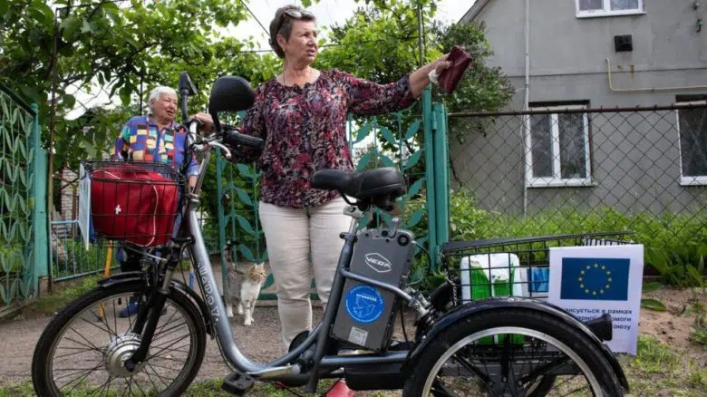 woman standing in front of her electric cycle