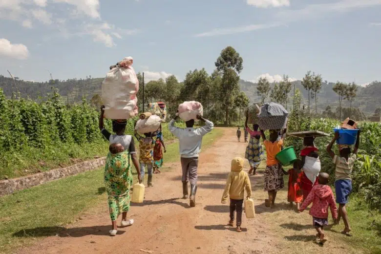 Families carrying belonging above their heads