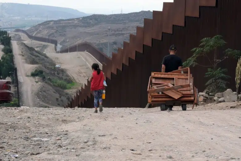 Person walking along a border fence.