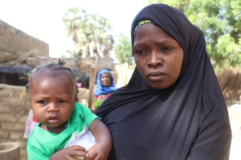 A woman holds her child.