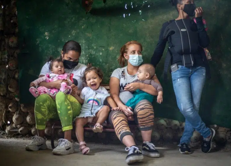 Refugee mothers sitting with their young children. 